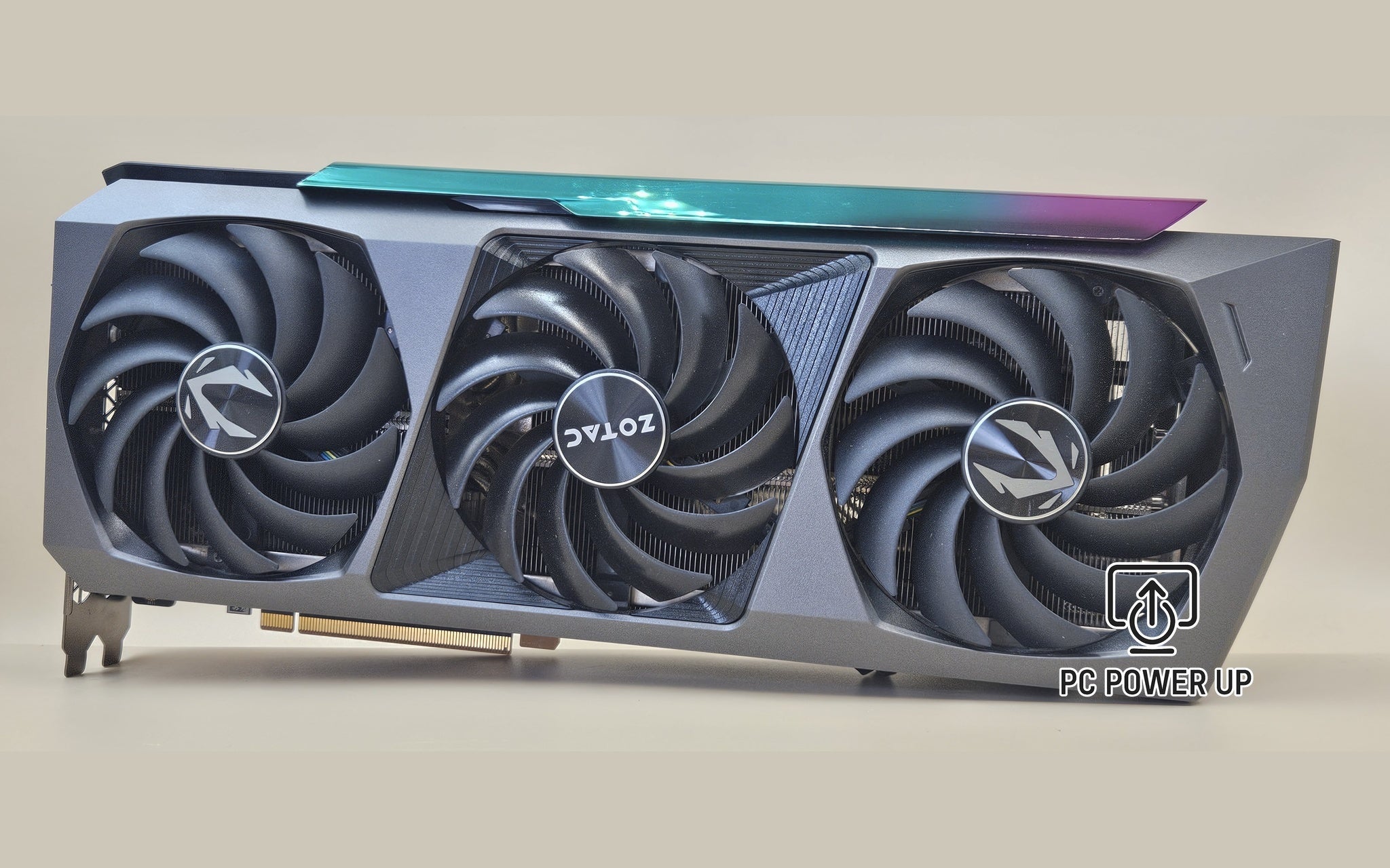Triple-fan ZOTAC GeForce RTX graphics card with black shroud and teal-purple top accent